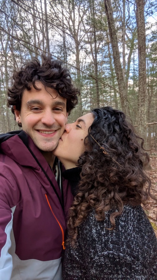A kiss on the cheek in the winter woods