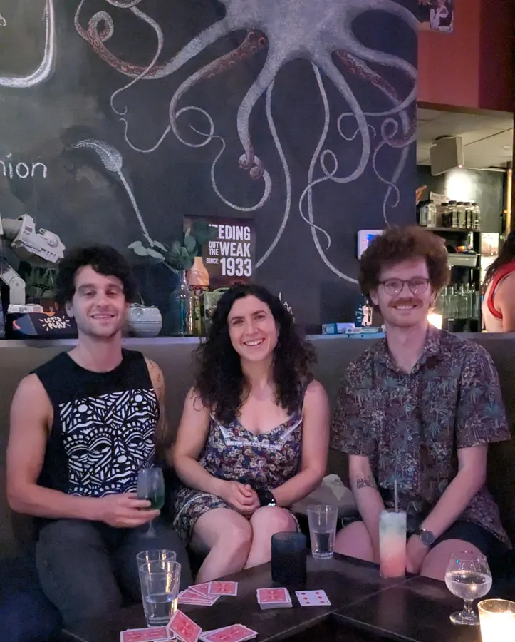 A card game at a bar under a chalk octopus