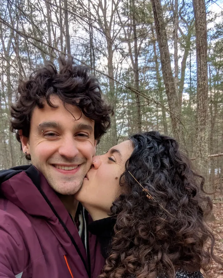 A kiss on the cheek in the winter woods