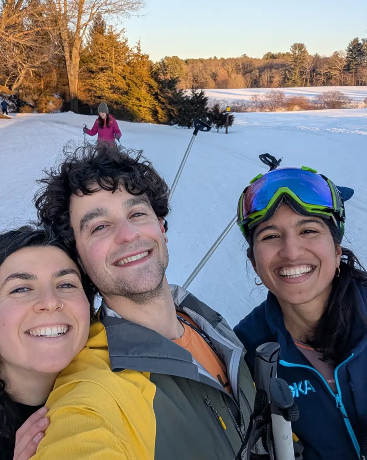 A three-way selfie on the ski slope at golden hour