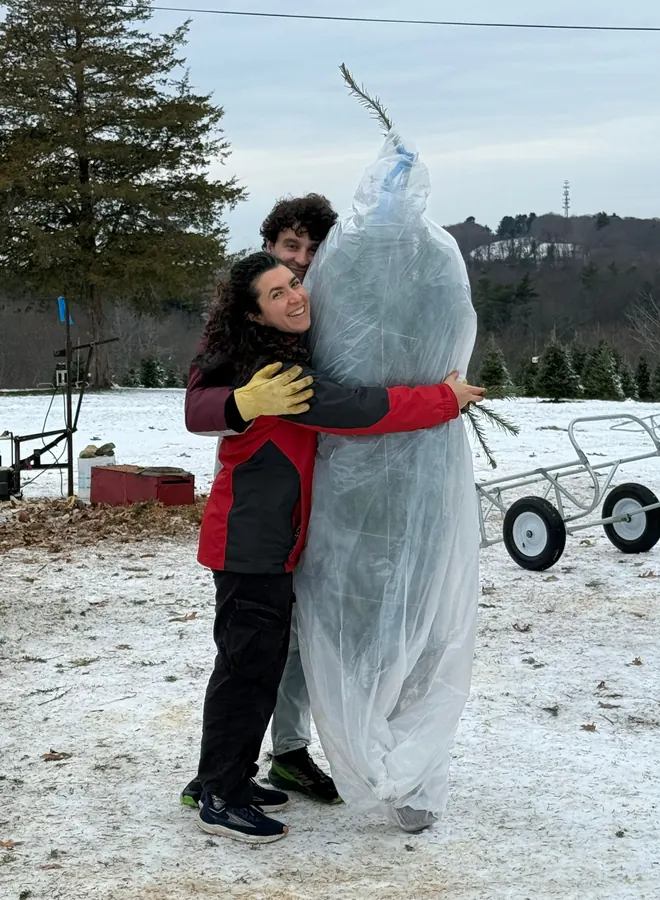 Hugging the wrapped Christmas tree, and each other