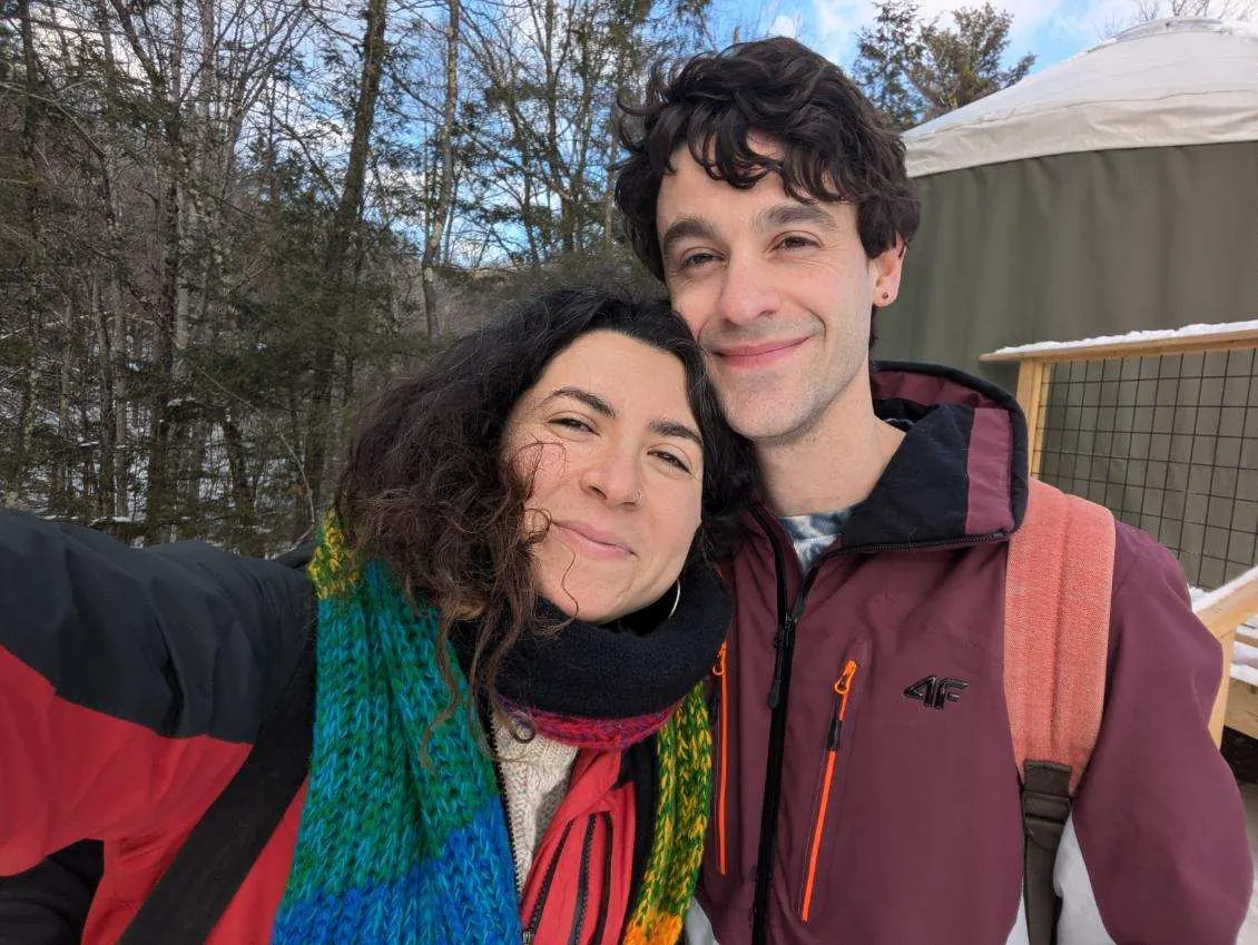 Bundled up outside a yurt in the snow